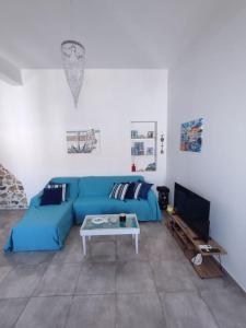 卡利诺岛Sunrise Apartments - Aegean Blue的客厅配有蓝色的沙发和桌子