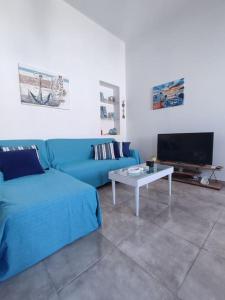 卡利诺岛Sunrise Apartments - Aegean Blue的客厅配有蓝色的沙发和桌子