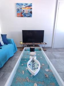 卡利诺岛Sunrise Apartments - Aegean Blue的客厅配有电视和桌子