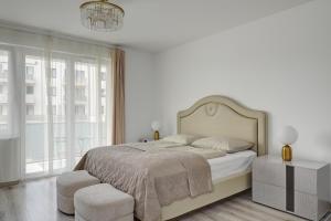 布达佩斯Vision Apartments Budapest的白色卧室配有一张大床和吊灯