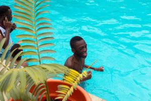 阿鲁沙Okaseni Lodge的游泳池里的人,有脚踏船