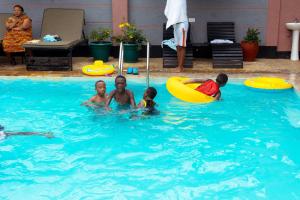 阿鲁沙Okaseni Lodge的一群人在游泳池玩耍