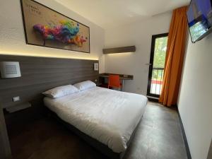 穆昂萨尔图Urban Style Cannes Mouans-Sartoux - Piscine Extérieure - Parking Gratuit的卧室配有一张床,墙上挂有绘画作品