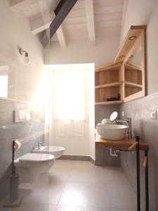 特雷莫西内appartamenti Residenza 1928的一间带水槽和卫生间的浴室以及窗户。