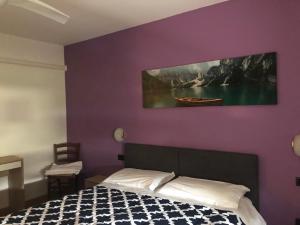Santa Giustinalocanda alla stazione的一间卧室配有一张床和紫色的墙壁