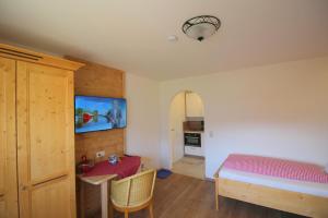 巴特莱辛哈尔莱特纳霍夫旅馆的一间卧室配有一张床、一张桌子和一台电视。