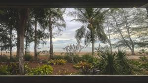 Ban Rang PlaSANTI beach retreat的从棕榈树窗户可欣赏到海滩景色