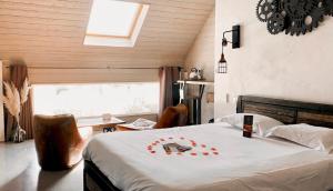 圣吉尔Abri Cosy - Suite Romantique的一间卧室配有一张带白色毯子的床和窗户。