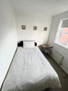 HeeleyCheerful Heeley Home的卧室配有一张带白色棉被的床和窗户。