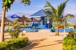 BakauSeaview 1-Bed Suite on Cape Point Beach Bakau的一个带游泳池、棕榈树和遮阳伞的度假村