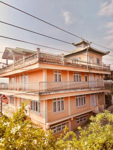 MirikSEWANS PLACE Homestay的一座橙色的建筑,上面设有一个阳台