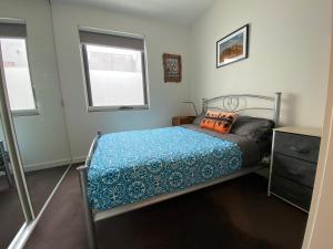 阿斯彭达尔Beach Life的一间卧室配有一张带蓝色棉被的床和窗户。