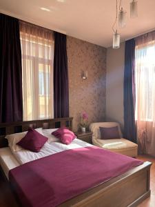 维丁维丁酒店的一间卧室配有一张大床和紫色毯子