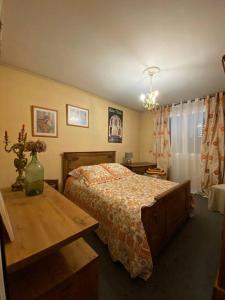 塞尔河畔阿尔帕容Les Marmottes的一间卧室配有一张床和一张木桌
