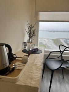 纳塔列斯港Hotel Costanera的厨房配有带咖啡设施和椅子的桌子