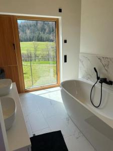 库罗阿尔滕堡Tolle Bergvilla im Osterzgebirge的白色的浴室设有大浴缸和窗户。