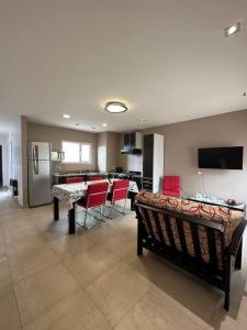 里瓦达维亚海军准将城Estepa Apart 1B calidad y confort的一间带红色椅子的客厅和一间厨房