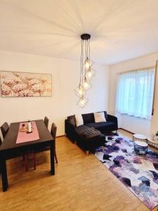 戈尔多拉Appartamento 4.5 - Gordola的客厅配有桌子和沙发