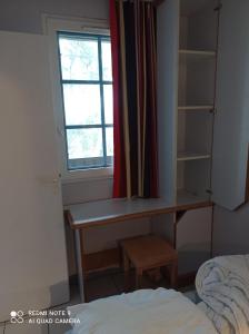 莫列马阿Chez Alex & Max - Appartement duplex entre forêt et océan的一间卧室设有书桌和窗户。