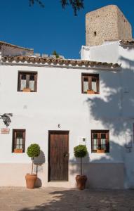 奥尔维拉Acogedora casa rural en Olvera ,La Morada的白色的建筑,有木门和盆栽植物
