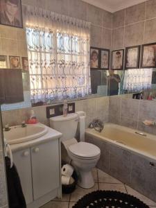 比勒陀利亚Home away from Home的浴室配有卫生间、浴缸和水槽。