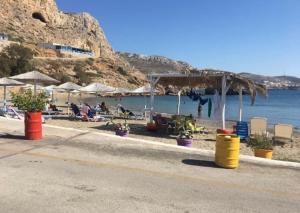 卡尔帕索斯Grannys Luxury Villas的海滩上设有椅子和遮阳伞,水面