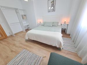 萨龙Apartamento de 120m2 al lado de Cabarceno的一间白色卧室,配有床和地毯