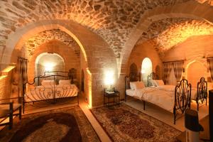 马尔丁Legacy Mesopotamia Hotel的砖墙内一间卧室,配有两张床
