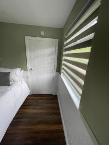 贝图瑟科伊德Tyddyn Bach Bunkhouse的卧室配有白色的床和窗户。