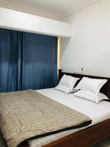 特马nanas@TEMA C11的一间卧室配有一张带蓝色窗帘的大床