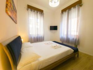 维罗纳Italianflat - Rentroom Verona的一间卧室配有一张带白色床单的床和一扇窗户。