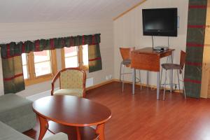 卡拉绍克杰古尔艾斯图山林小屋的客厅配有电视和桌椅