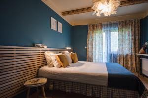 SăliceaLa Mesteceni & Loc cu Stări de Bine, SPA adult only的一间卧室配有一张带蓝色墙壁和吊灯的床。