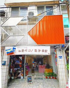 花莲市博愛泊旅讀心境的一座带橙色屋顶的建筑的前方的商店