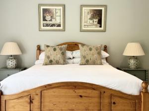 汤顿Farthings Country House Hotel & Restaurant Tunton的一间卧室配有一张带两盏灯的木床。