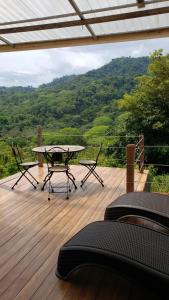 SavegreCabina Brisa Escondida - Walking distance from river的木制甲板上配有桌椅的天井