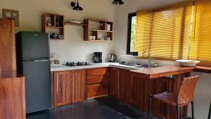SavegreCabina Brisa Escondida - Walking distance from river的厨房配有木制橱柜和冰箱。