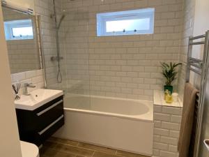 利明顿Oakwood的白色的浴室设有浴缸、水槽和水槽。