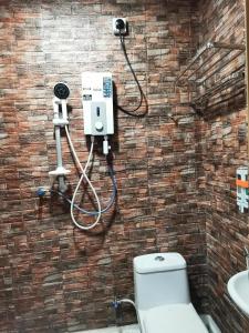 阿罗士打Tang Hotel的浴室设有卫生间,砖墙上设有摄像头