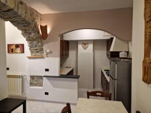 OrtonovoCasa Romantica Tra Liguria e Toscana的厨房设有石拱门和桌子