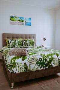 努尔德The Palm Leaf Apartments的一间卧室配有一张带绿色和白色棉被的床