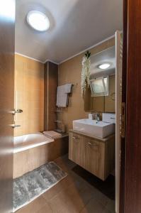 海若克利欧MegaLuxe Apartment的带浴缸、水槽和镜子的浴室
