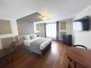 阿雷基帕帆迪朵酒店的酒店客房设有一张大床和一张桌子。