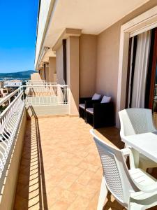 阿尔盖罗三角帆度假酒店的阳台配有桌椅和沙发。