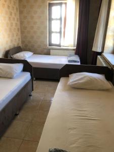 科尼亚ESER PALAS OTELİ的客房设有两张床和窗户。