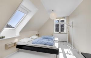 古兹耶姆Cozy Apartment In Gudhjem With Kitchen的一间设有床铺的卧室,位于带窗户的白色客房内