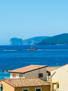 阿尔盖罗三角帆度假酒店的远处有一座灯塔的一大片水体