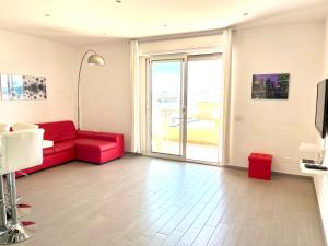 阿尔盖罗三角帆度假酒店的客厅设有红色的沙发和窗户。