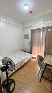 马尼拉Jannah’pad的一间卧室配有一张床、一张桌子和一把椅子