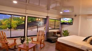 El FosforoLove Cabin - Arenal Volcano & Lake views的一间卧室设有一张床和一间客厅。